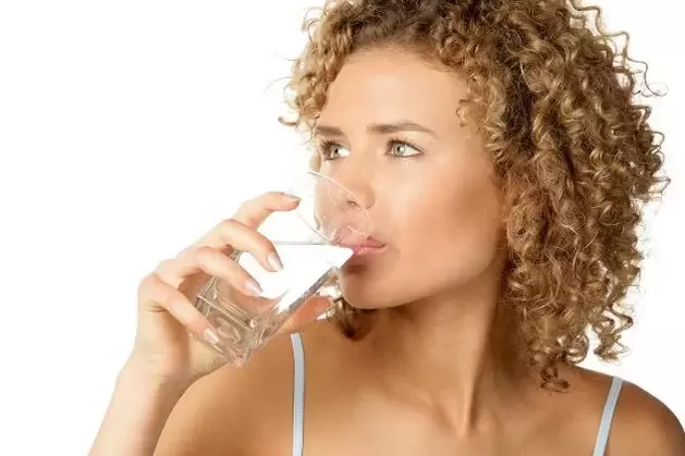 The girl goes on a lazy diet and drinks a glass of water before eating
